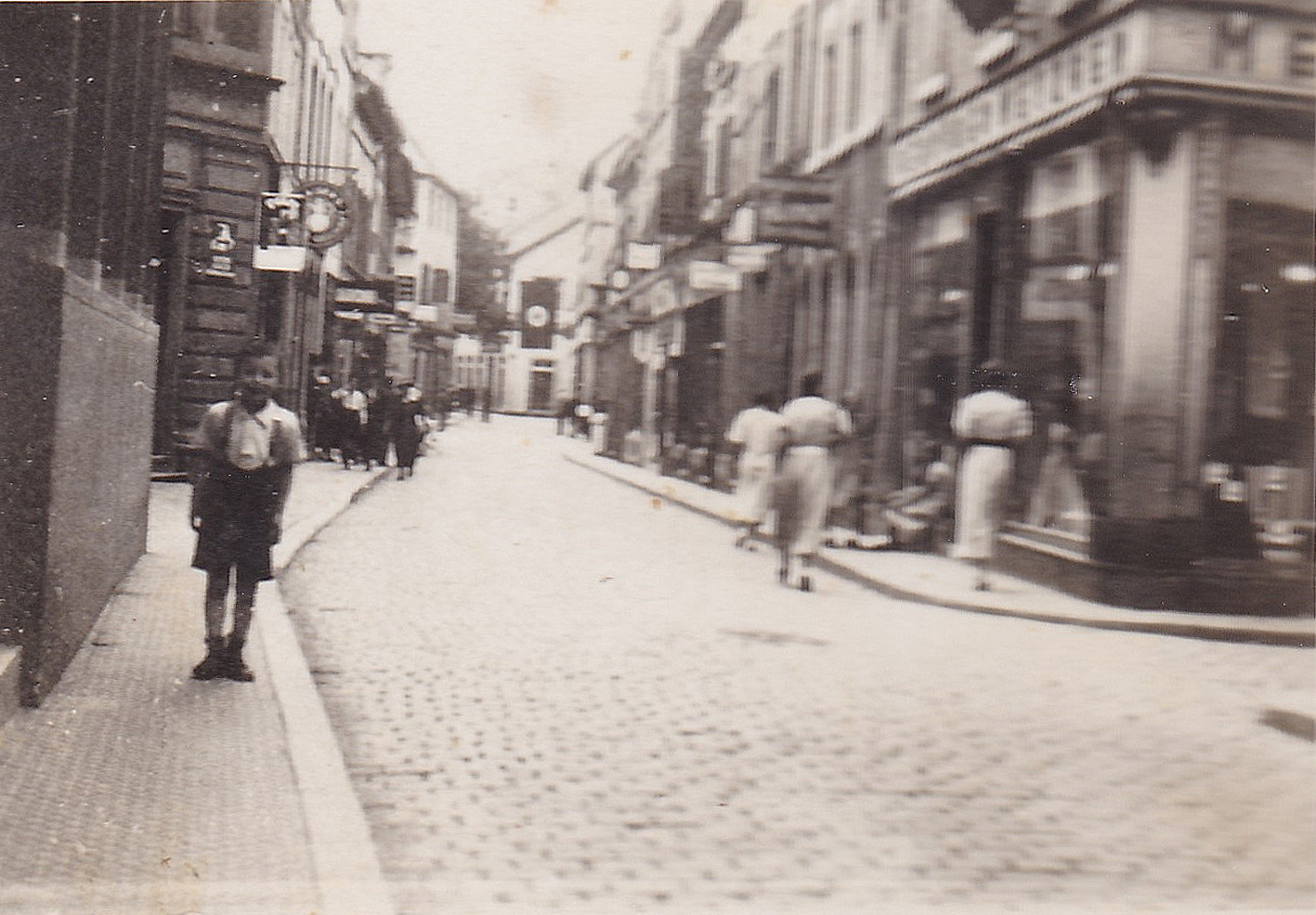 Little Herbert (left) in front of his father's butcher's shop (right).